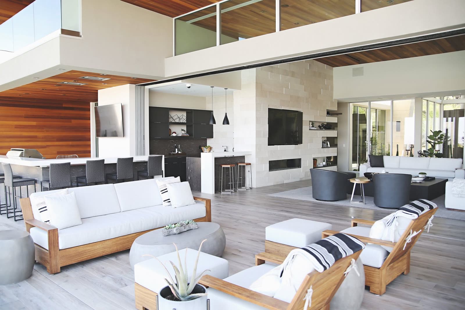 Open-plan great room with a timber ceiling and pocketing glass walls
