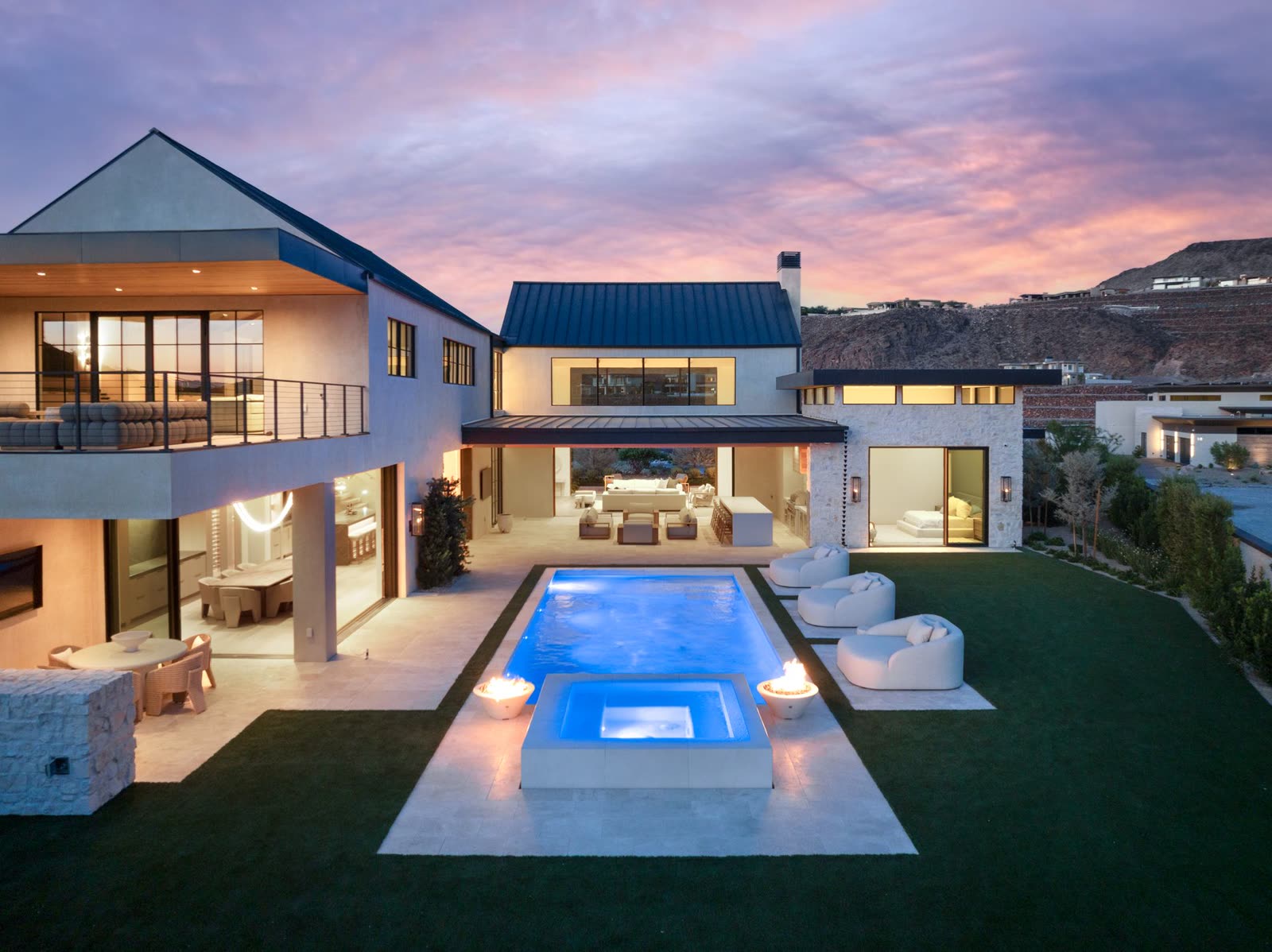 Rear elevation and pool of a custom home lit at twilight