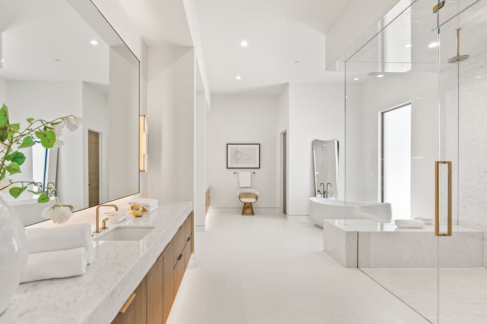 Primary bathroom in pale stone with a glazed shower