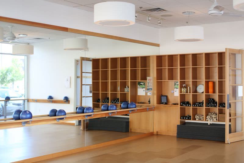 A fitness studio fit-out with timber shelving and a mirrored wall